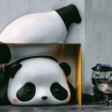 a giant panda bear statue sitting next to a building related to Panda Crib Bedding: The Perfect Blend of Cuteness and Comfort