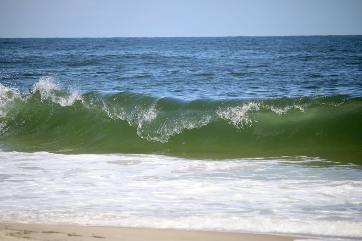 A green wave crashes on the shore. related to Discover the Charm of Rehoboth Beach Bed and Breakfasts