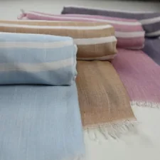 a group of different colors of blankets on a table related to How to Drape a Valance Scarf