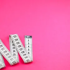 a group of measuring tape sitting on top of a pink surface related to Understanding Queen Size Bed Dimensions
