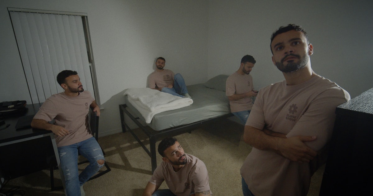 a group of men sitting around a bed in a room related to Exploring the Lives of Jewish Men at Home