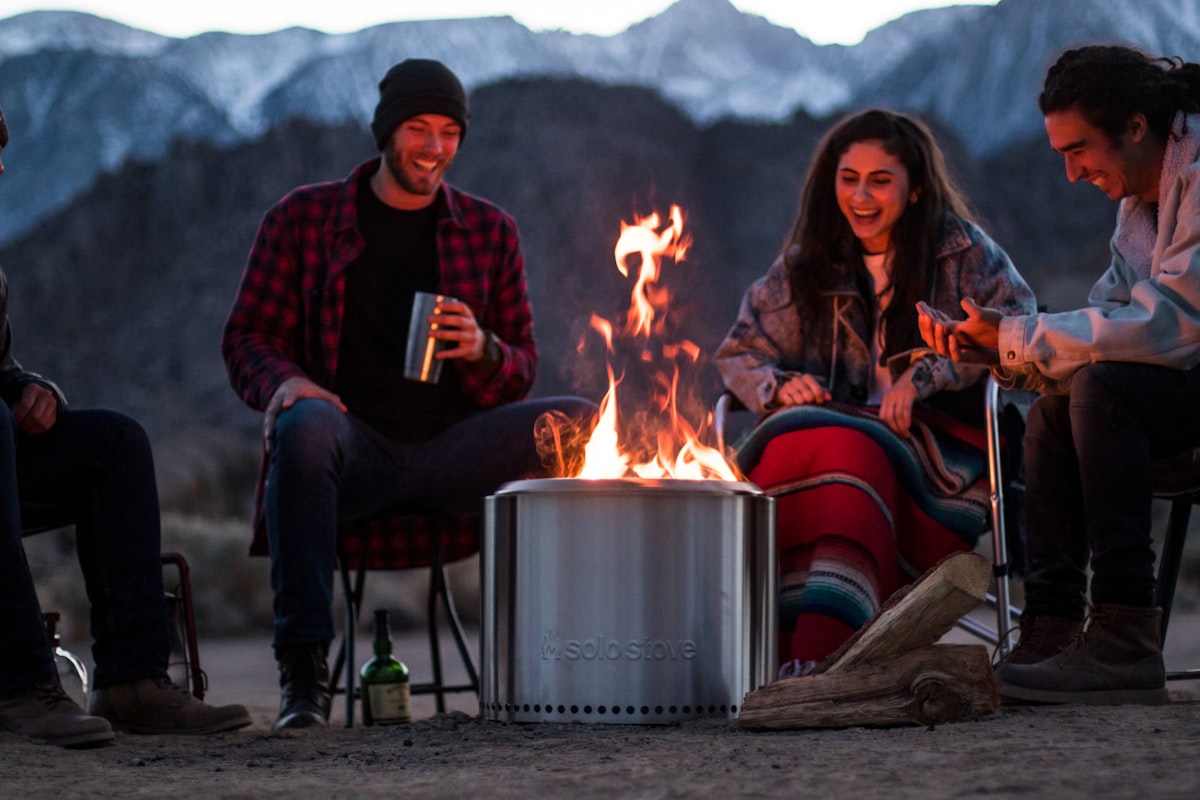 a group of people sitting around a fire pit related to The Ultimate Guide to Truck Bed Camping