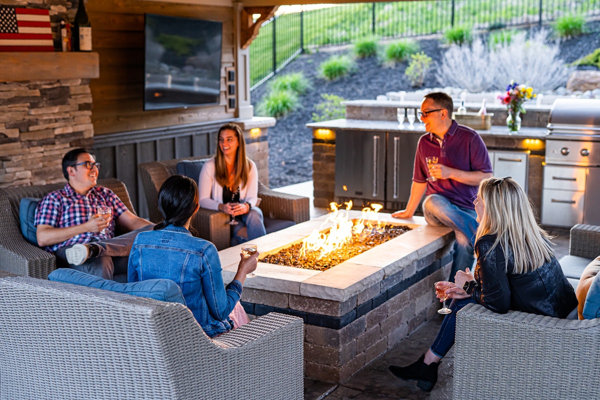 a group of people sitting around a table with a fire in it related to Warm Up Your Patio: A Comprehensive Guide to Cast Iron Chiminea Reviews