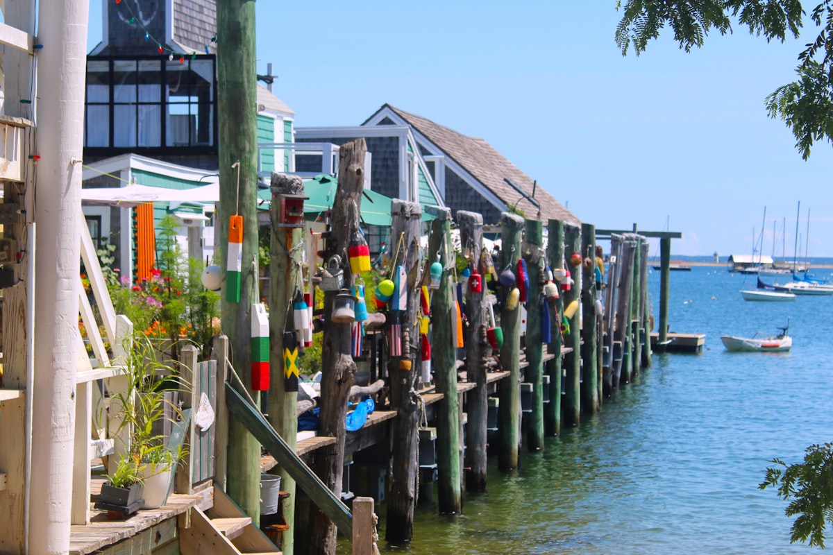 A group of people standing on a dock next to a body of water related to Provincetown B&B Paradise Found
