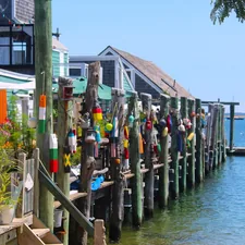 A group of people standing on a dock next to a body of water related to Provincetown B&B Paradise Found
