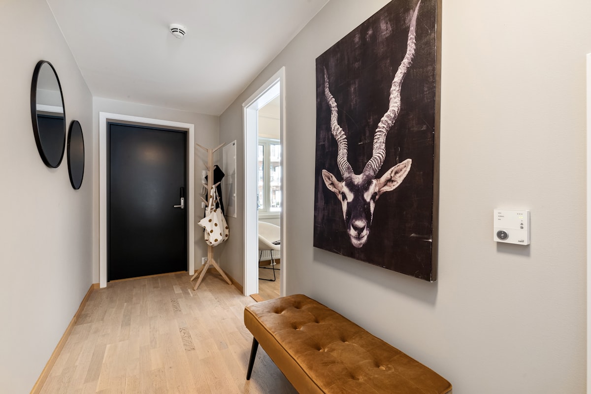 A hallway with a bench and paintings on the wall related to Elevate Your Entrance: The Ultimate Black Entryway Bench Guide