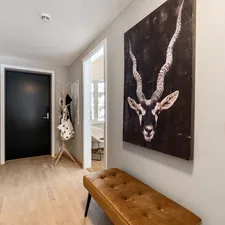 A hallway with a bench and paintings on the wall related to Elevate Your Entrance: The Ultimate Black Entryway Bench Guide