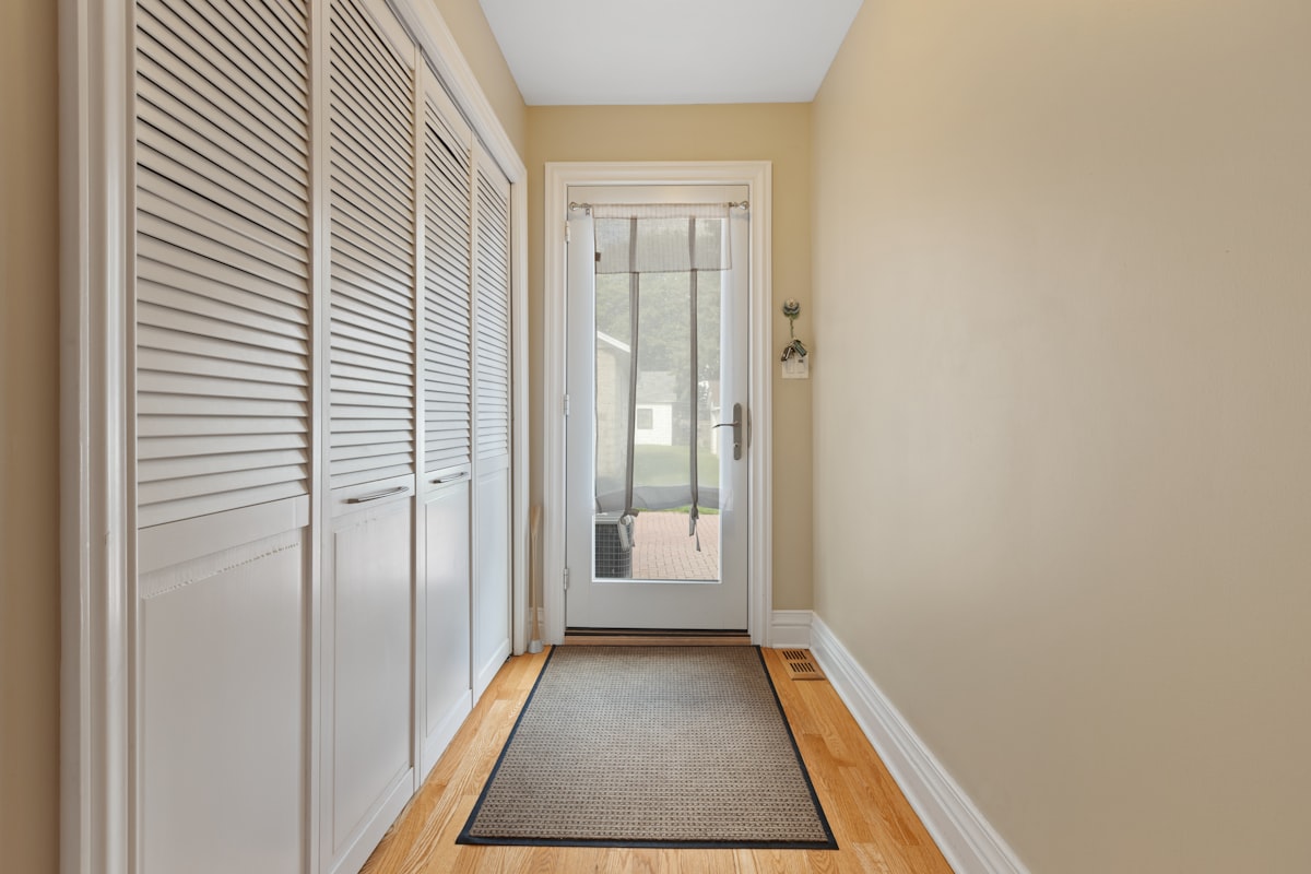 a hallway with a door and a rug on the floor related to Maximizing Space and Style with Entryway Storage Furniture