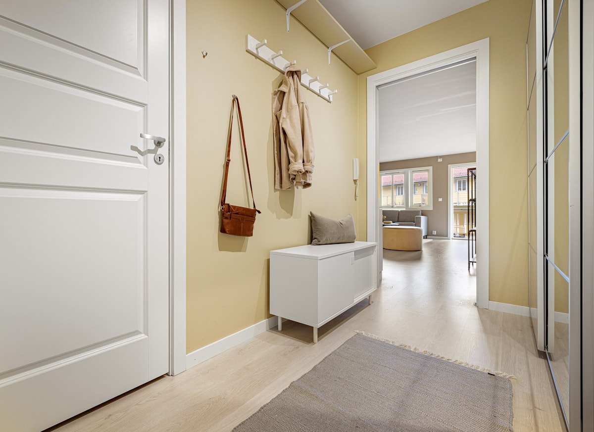 A hallway with a white door and yellow walls related to Elevate Your Entryway with Elegance: White Entryway Bench Ideas
