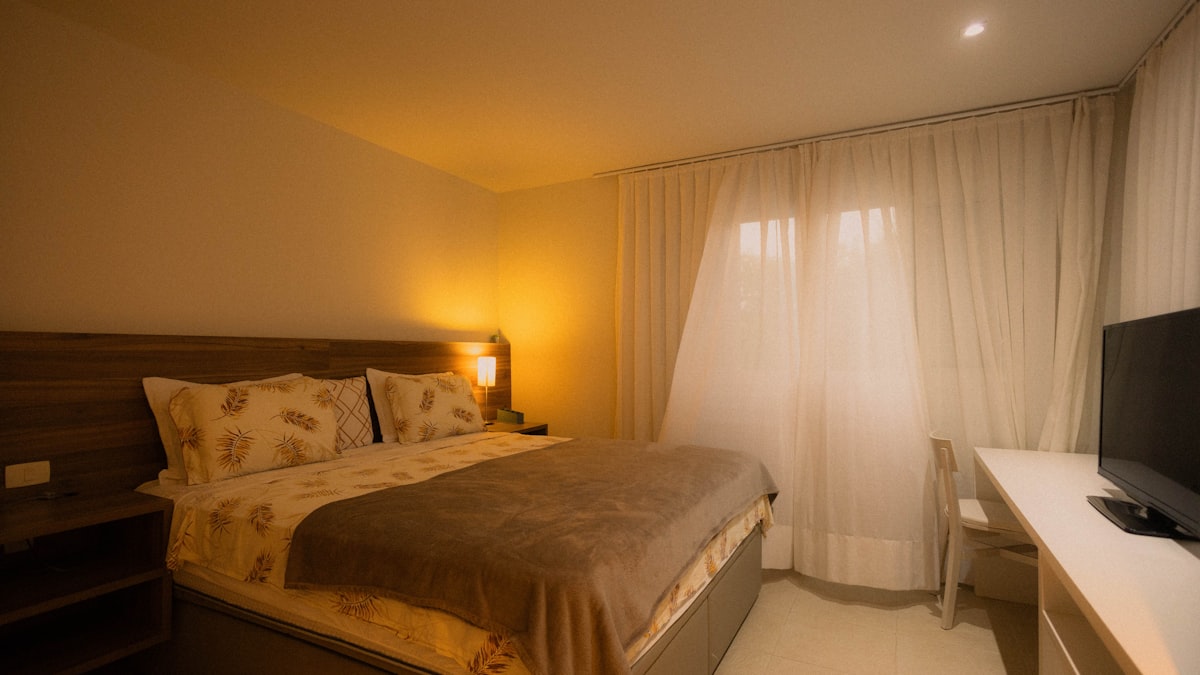 A hotel room with a bed and television related to Best Bed Chair Pillows for Comfort and Support