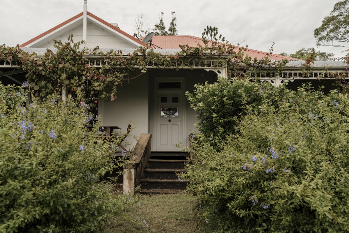 a house with a white door surrounded by bushes related to Unwind in Walla Walla: Bed and Breakfast Bliss Awaits