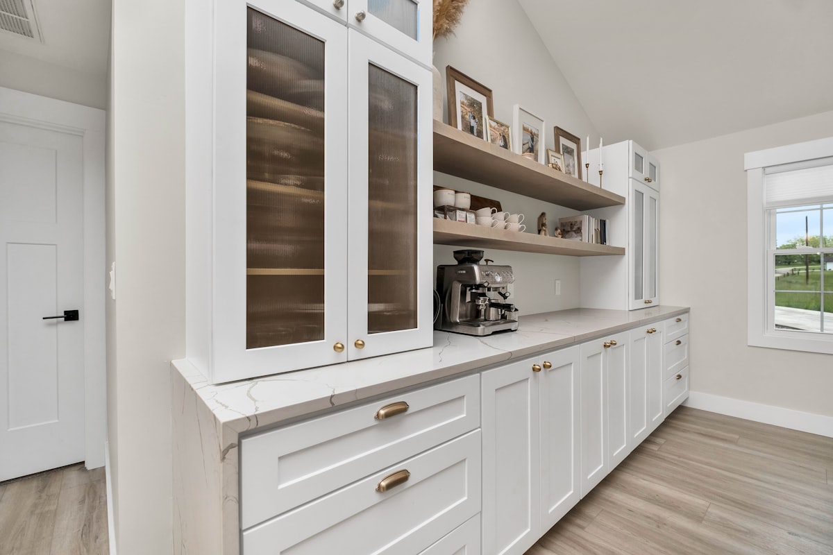 a kitchen with white cabinets and wood floors related to Elevate Your Kitchen: Discover the Perfect Kitchen Sideboard Cabinet