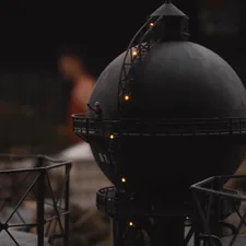 a large black object with some lights on top of it related to Chiminea vs Fire Pit: Choosing the Perfect Outdoor Fireplace