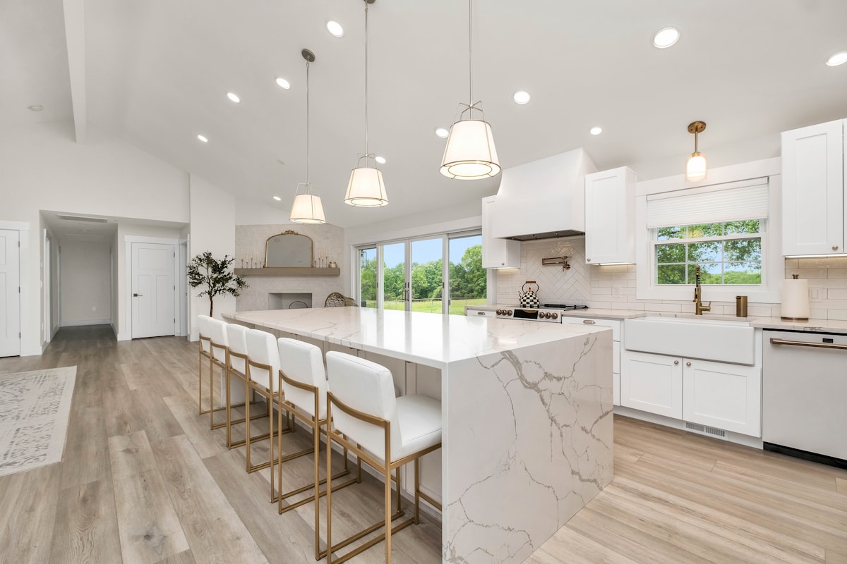 a large kitchen with a marble island and white cabinets related to Elevate Your Kitchen Style: Modern Valances for Windows