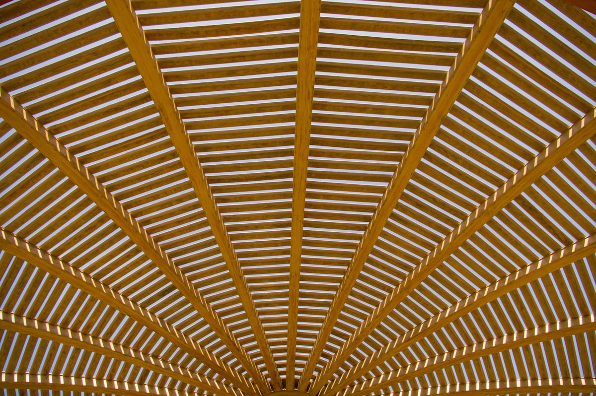 a large open area with a wooden ceiling related to Elevate Your Home's Curb Appeal with These Stunning Entryway Roof Designs