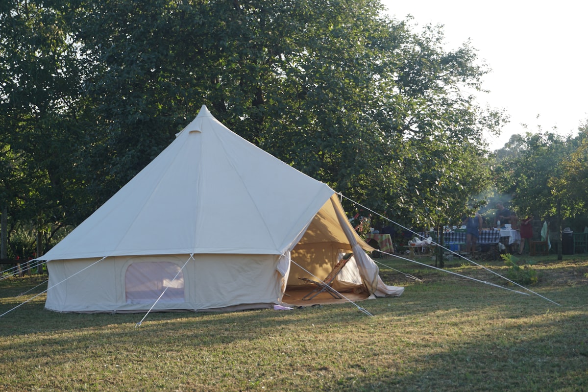 A large white tent sitting on top of a lush green field related to Ultimate Guide to Choosing a Tent for Full Size Bed