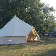 A large white tent sitting on top of a lush green field related to Ultimate Guide to Choosing a Tent for Full Size Bed