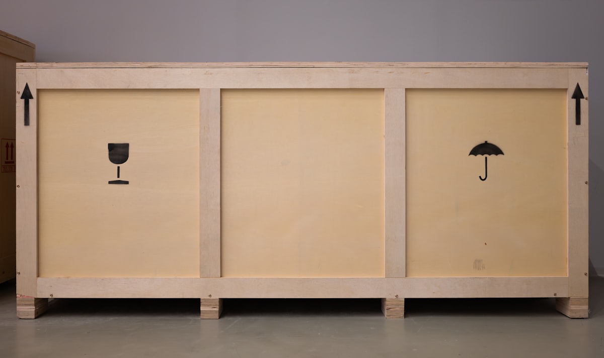 A large wooden crate with shipping symbols. related to Elevate Your Home Decor: The Ultimate Guide to Real Wood Sideboards