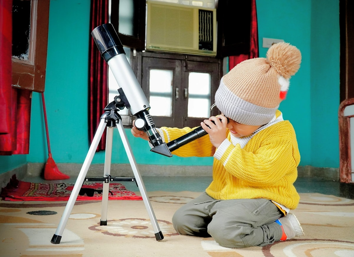 a little boy sitting on the floor looking through a telescope related to Exploring the Popularity and Reach of Bed Bath & Beyond