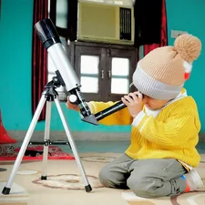a little boy sitting on the floor looking through a telescope related to Exploring the Popularity and Reach of Bed Bath & Beyond