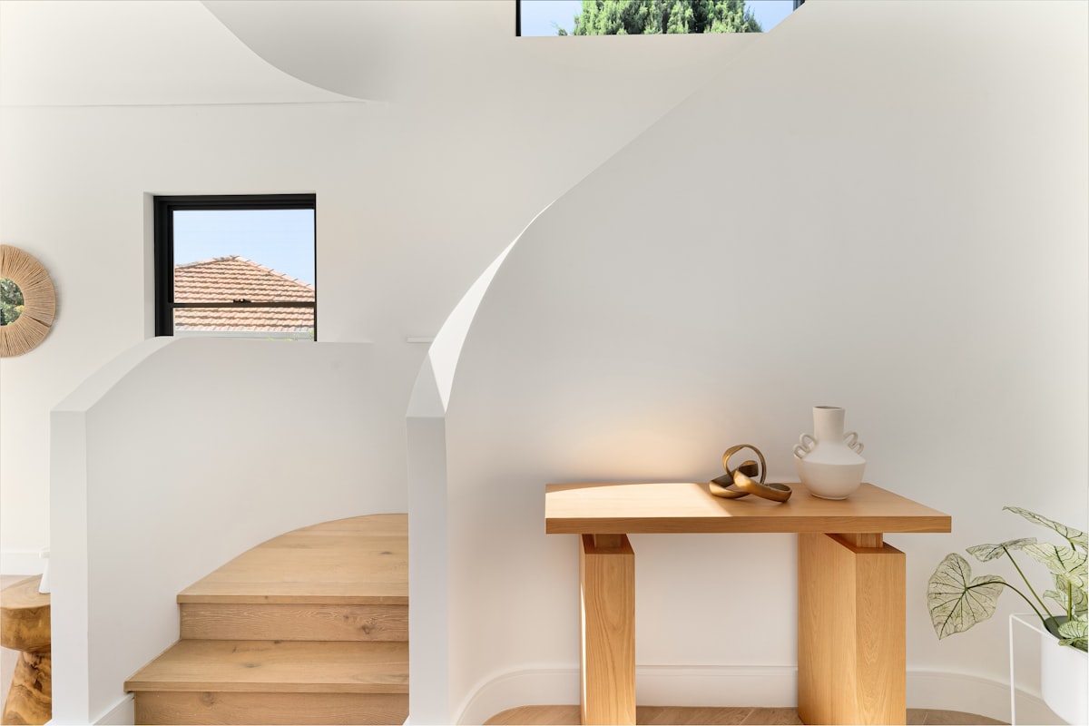A living room with a table and stairs related to Stunning Unique Entryway Tables to Elevate Your Home's Style
