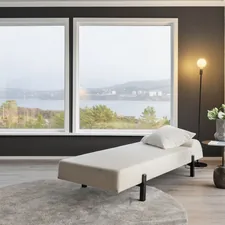 A living room with large windows and a white couch related to Sleep Soundly and Comfortably with an Adjustable Bed Frame