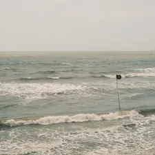 A lone black flag stands in the choppy ocean waves. related to Explore the Best Home Essentials in Flagstaff