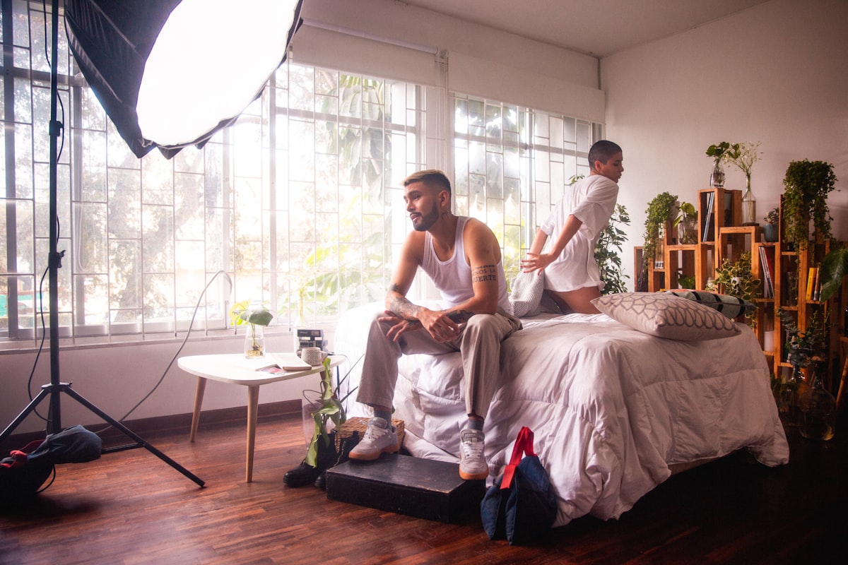 a man and a woman sitting on a bed related to The Ultimate Guide to Bed Dividers for Couples