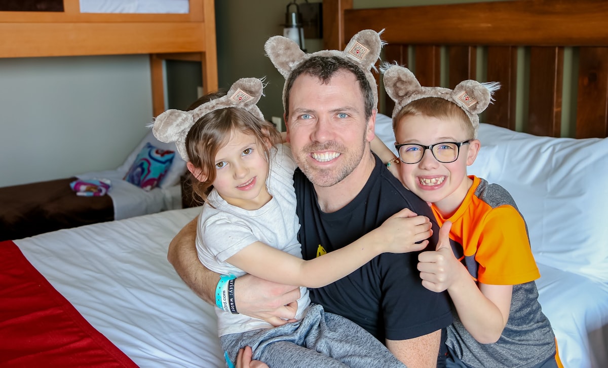 a man and two children sitting on a bed related to Enchanting Bedtime Adventures