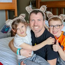 a man and two children sitting on a bed related to Enchanting Bedtime Adventures