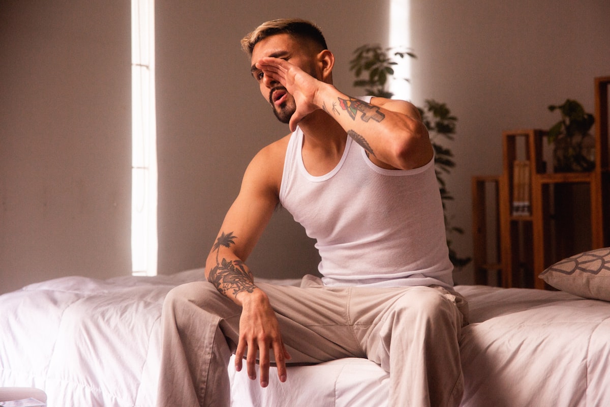 a man sitting on top of a bed in a room related to Decoding the Desire: Cancer Man's Guide to Intimacy
