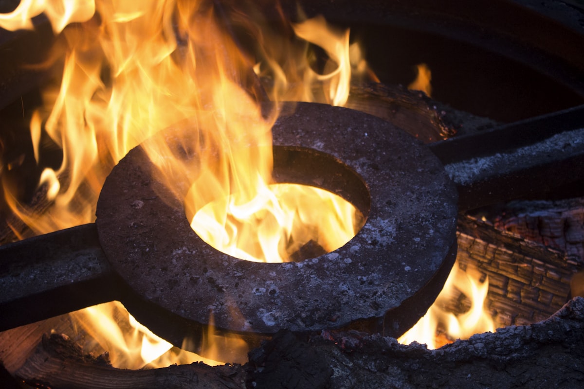 a metal ring sitting on top of a fire related to Forge Your Own Fiery Oasis: Create Your Dream Chiminea!