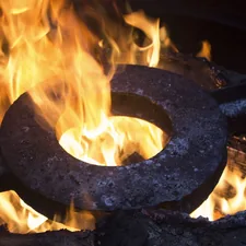 a metal ring sitting on top of a fire related to Forge Your Own Fiery Oasis: Create Your Dream Chiminea!