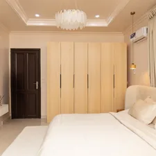 A modern bedroom with a bed, wardrobes, and television. related to Maximize Space with Stylish Loft Beds Featuring Storage Options