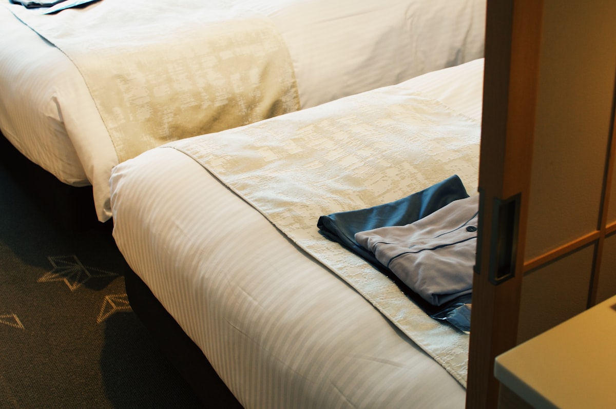 a pair of white beds sitting next to each other related to The Ultimate Guide to Twin Bed Sizes and Measurements