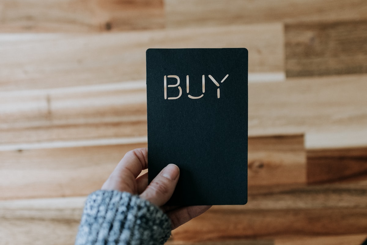 a person holding a black book with the word buy written on it related to Where to Buy Valances