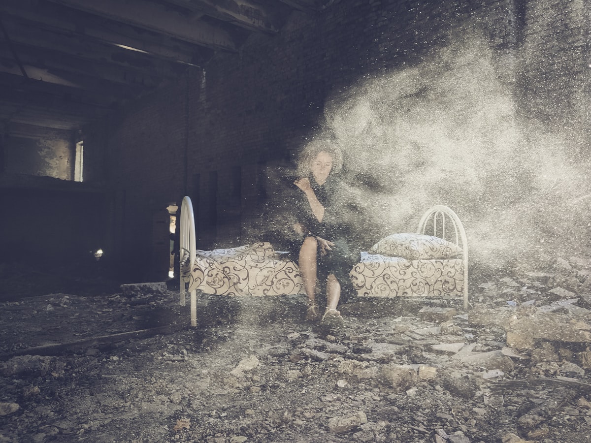 a person sitting on a bed in a room related to The Hidden Dangers of Smoking Bed Bugs: What You Need to Know