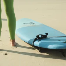 A person standing next to a surfboard on a beach related to Elevate Your Home Decor with Ready Made Sideboards
