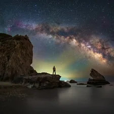 A person standing on a rock looking at the stars related to Exploring the Cosmic Dreams: Galaxy Bed Spread