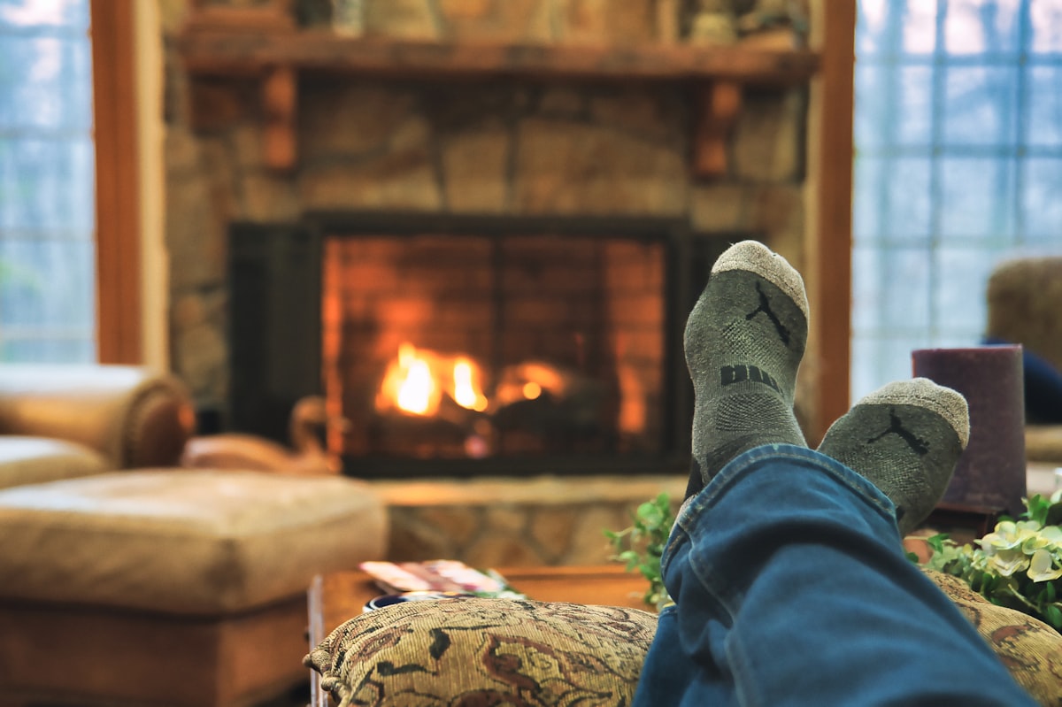 A pic showing feet getting warm in a winter cabin. related to Cozy Up with the Perfect Chiminea: A Guide