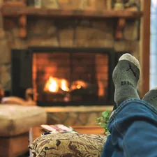A pic showing feet getting warm in a winter cabin. related to Cozy Up with the Perfect Chiminea: A Guide