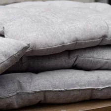 a pile of pillows sitting on top of a wooden table related to Linen Quilts & Coverlets: Timeless Elegance for Your Bed