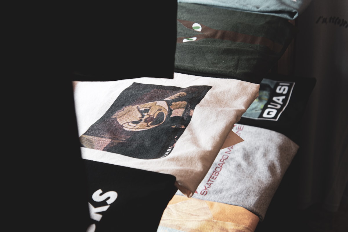a pile of shirts sitting on top of a bed related to Level Up Your Lounge: Swag Curtains with Valance