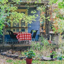 A porch with a checkered tablecloth and chairs related to Transform Your Garden with Home Depot's Raised Beds: The Ultimate Guide