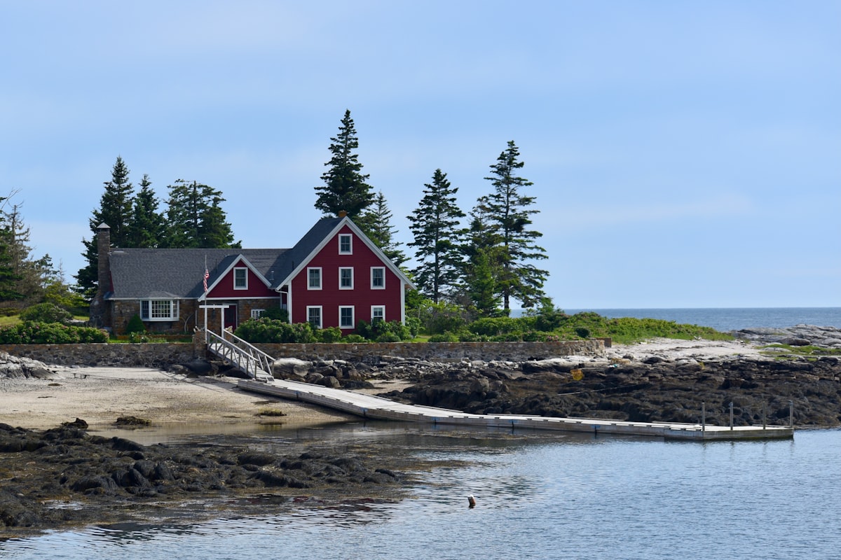 a red house on a rocky shore related to Discover the Charm of Bed and Breakfast Maine