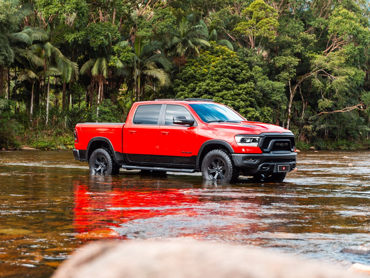 A red truck wades through shallow water. related to Top Bed Covers for Ram 1500: Ultimate Guide for Style and Protection