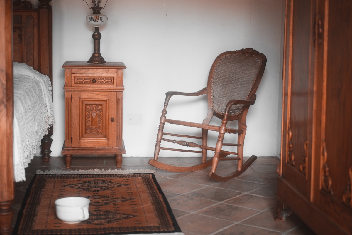 a rocking chair in a room with a rug on the floor related to Rocking Your Way to Relaxation: The Benefits of Rocking Beds for Adults