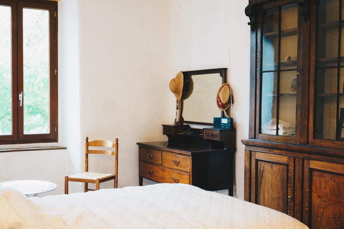 a room with a bed and a mirror related to The Evolution of End of Bed Dressers: A Look Back and a New Era