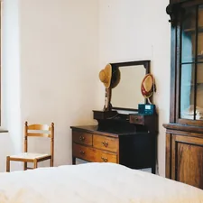 a room with a bed and a mirror related to The Evolution of End of Bed Dressers: A Look Back and a New Era