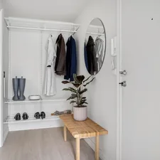 A room with a bench, coat rack, and mirror related to Elegant Entryway Solution: Mirror with Hooks and Shelf